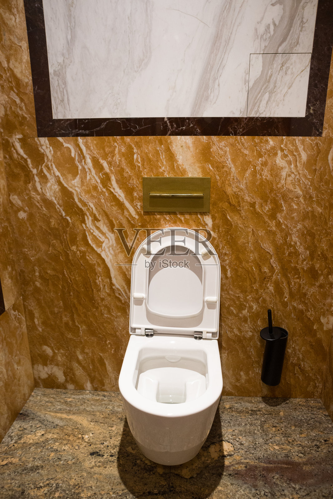 一个白色马桶位于墙壁上有时尚瓷砖的房间里。餐厅里的马桶。照片摄影图片