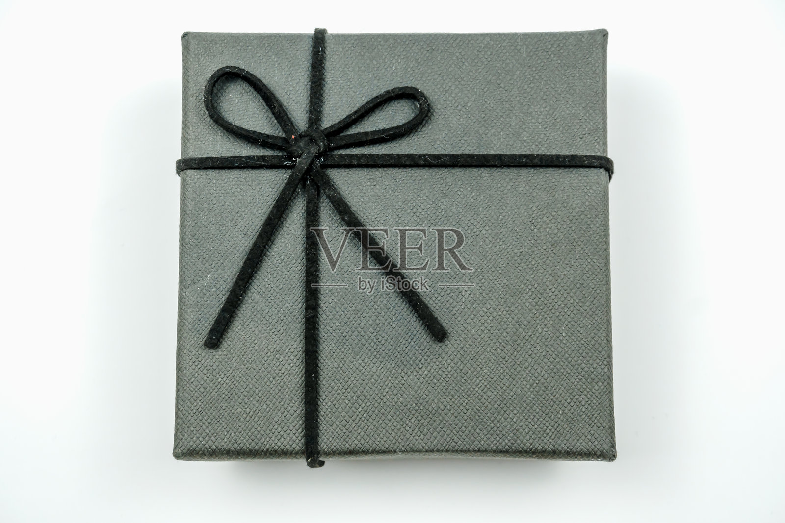 一个光滑的灰色礼品盒，优雅地系着黑色丝带，适合任何场合或庆祝活动。照片摄影图片