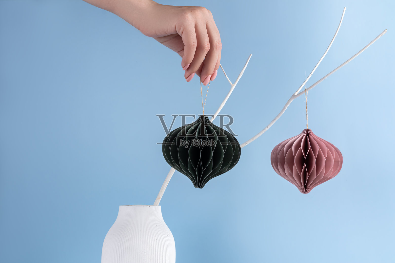 斯堪的纳维亚风格的圣诞纸灯笼装饰挂在树枝上。现代可持续的圣诞装饰，简约且无塑料。照片摄影图片