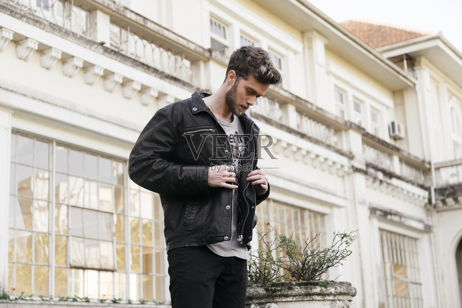 年轻男子站在建筑旁照片摄影图片
