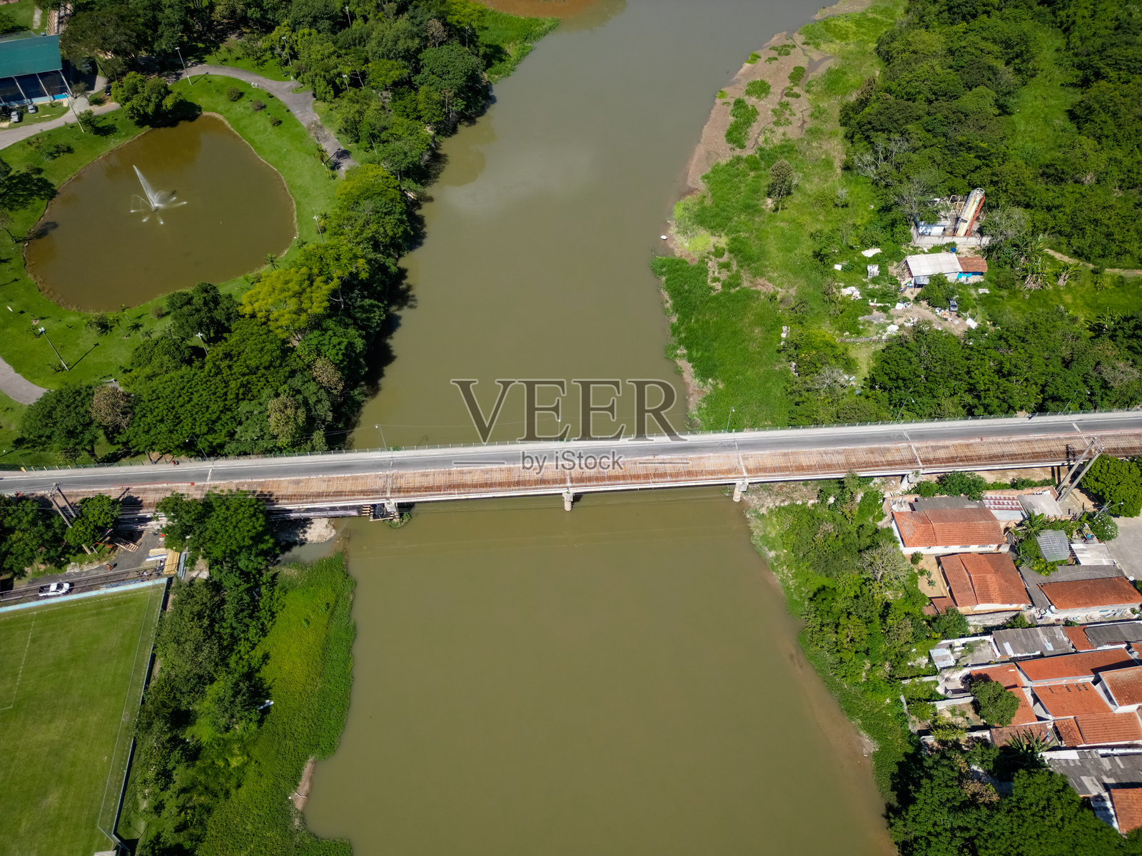 从高处俯瞰的自然环境中，开放的污水与植被覆盖的区域。照片摄影图片
