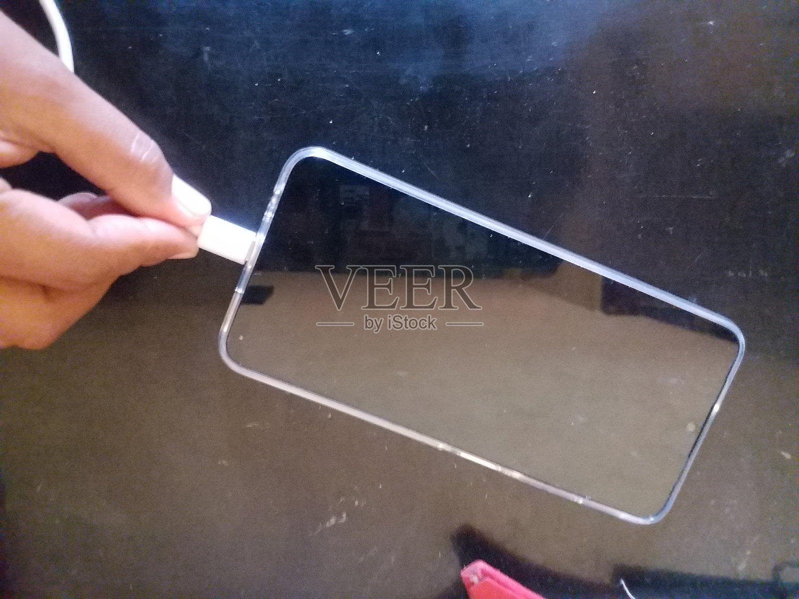 某人的手正在插入智能手机充电线照片摄影图片