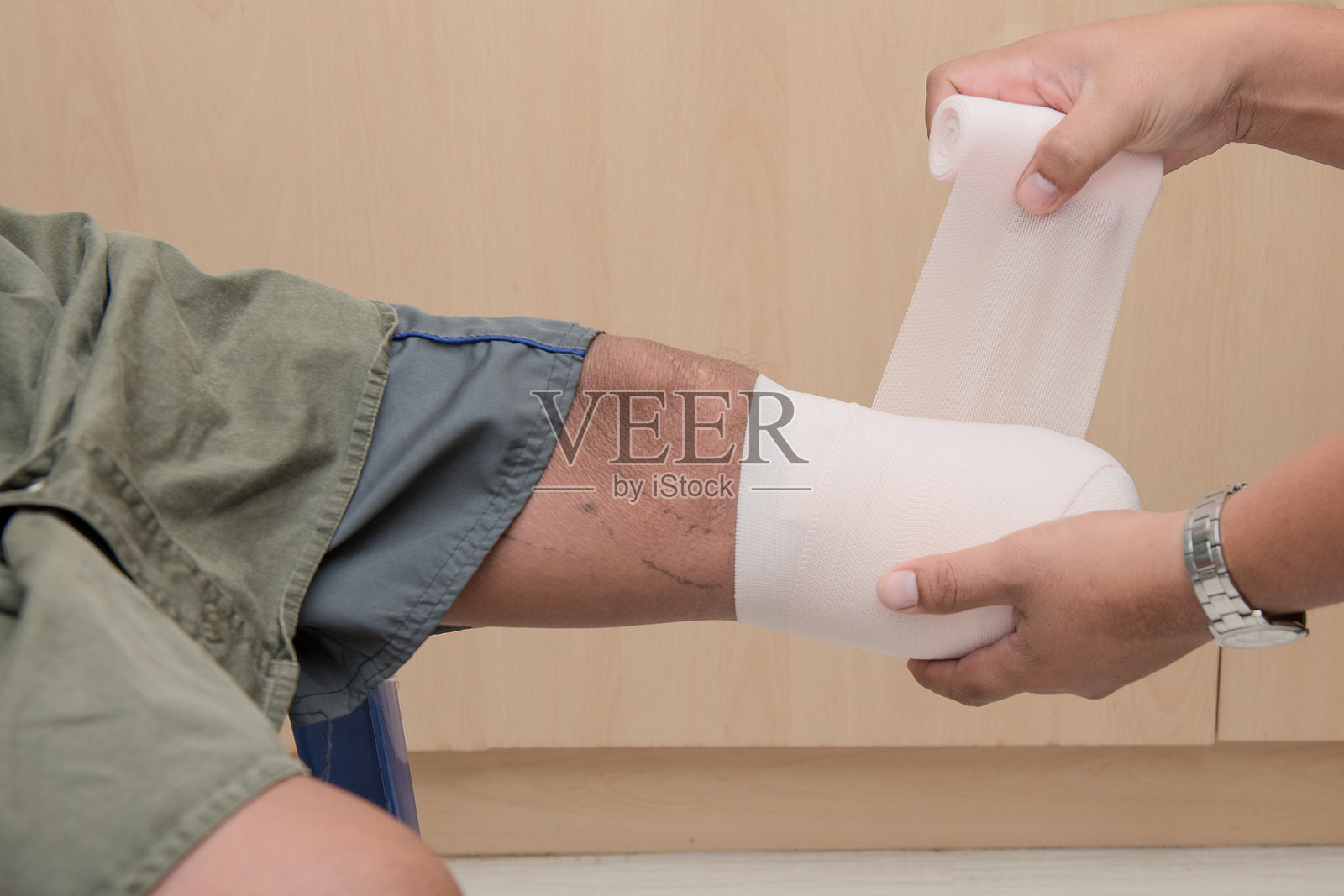 医生在医院为腿部包扎绷带的手部特写照片摄影图片