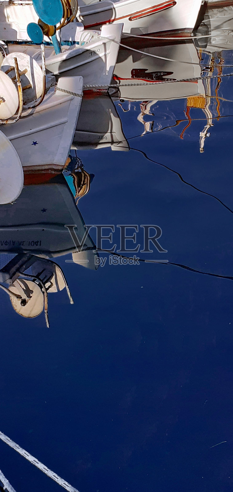 停泊在希腊斯佩茨岛旧港的渔船在水面上的倒影照片摄影图片
