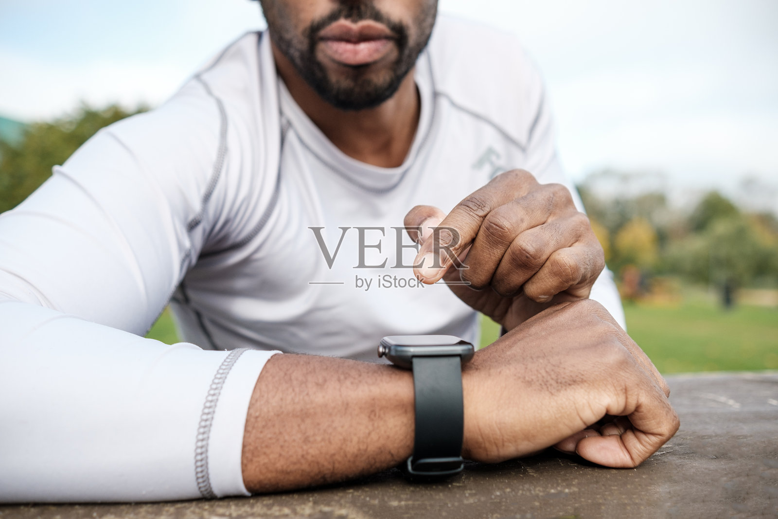 运动员在公园训练间歇时使用智能手表照片摄影图片