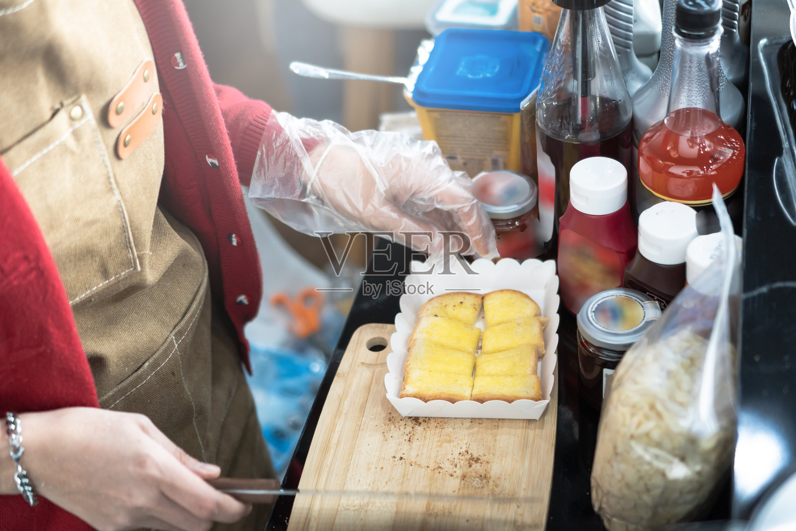 亚洲人手制作面包，咖啡馆厨房，为顾客和家庭烹饪，涂黄油的面包，吐司照片摄影图片