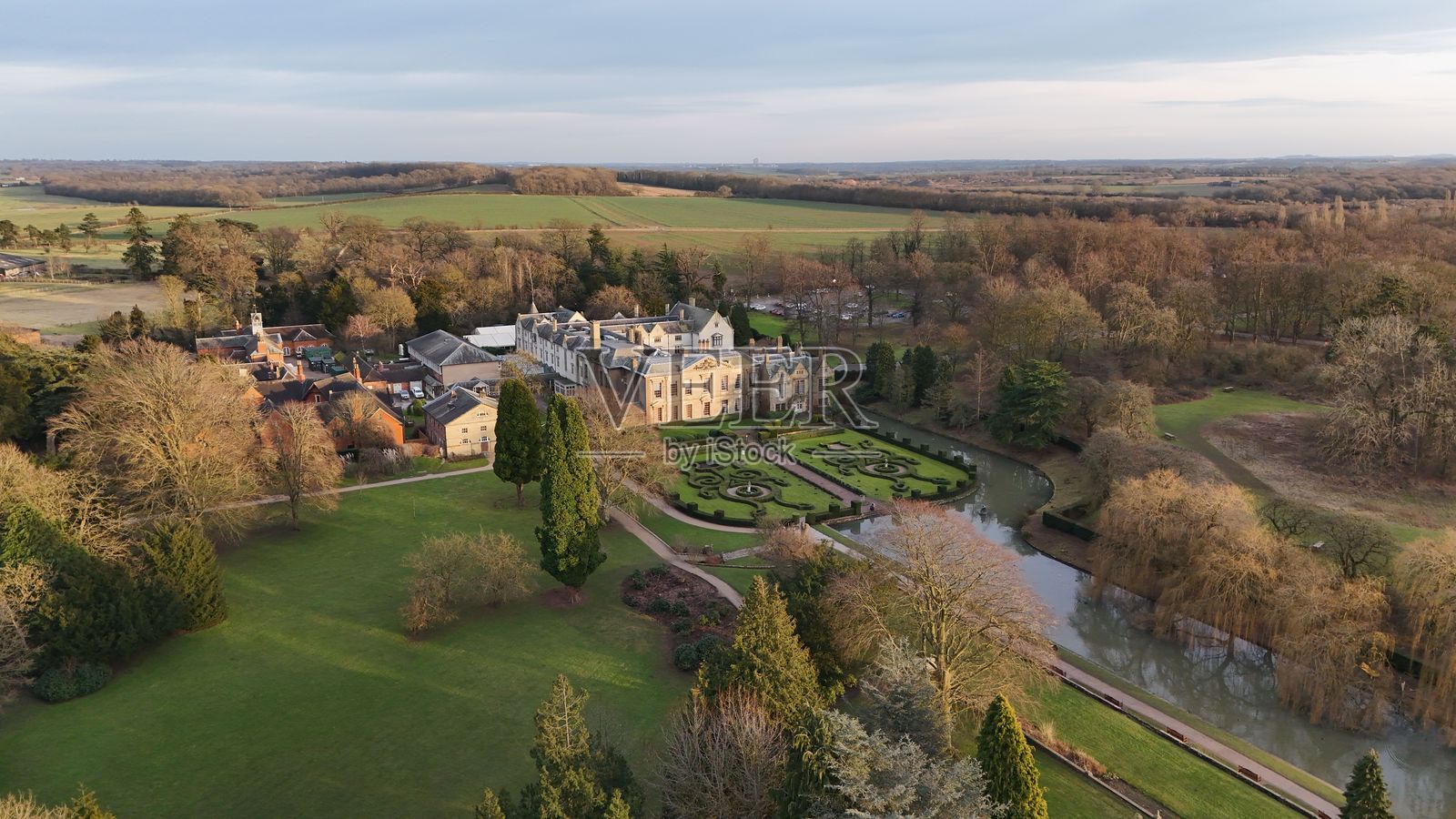 春季初期，俯瞰被修剪整齐的花园和郁郁葱葱的乡村环绕的库姆修道院。照片摄影图片