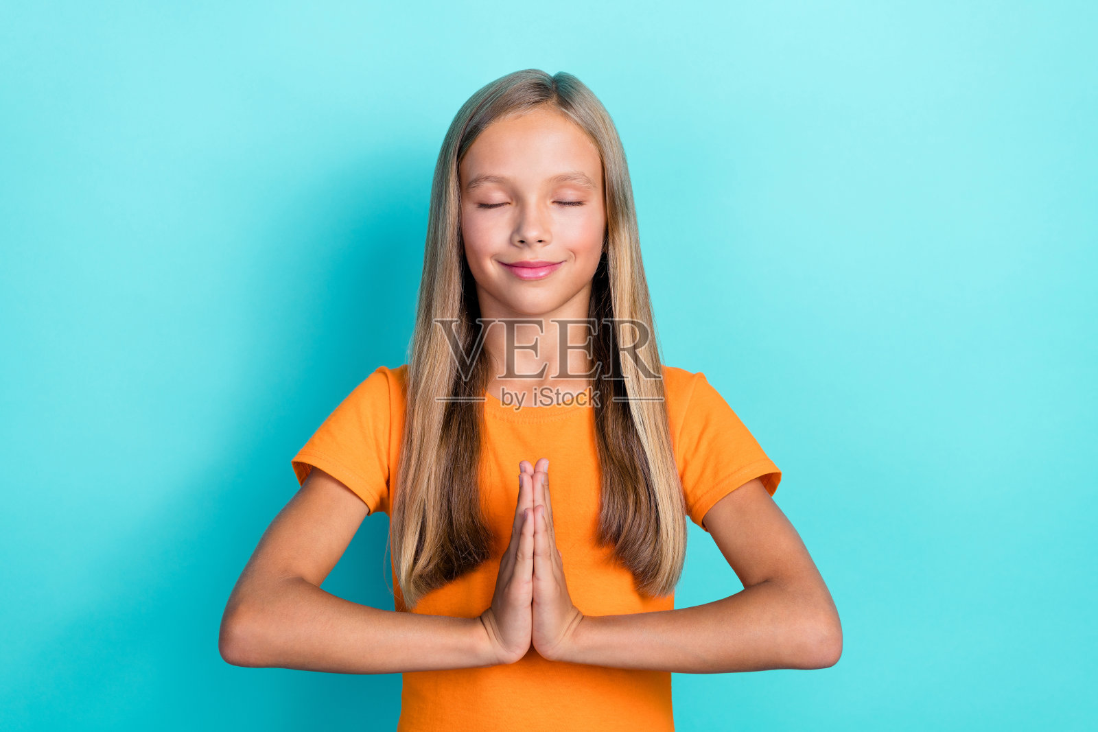 可爱的年轻女孩，金色长发，放松地双手托腮，课后在青色背景下梦想着下个周末。照片摄影图片