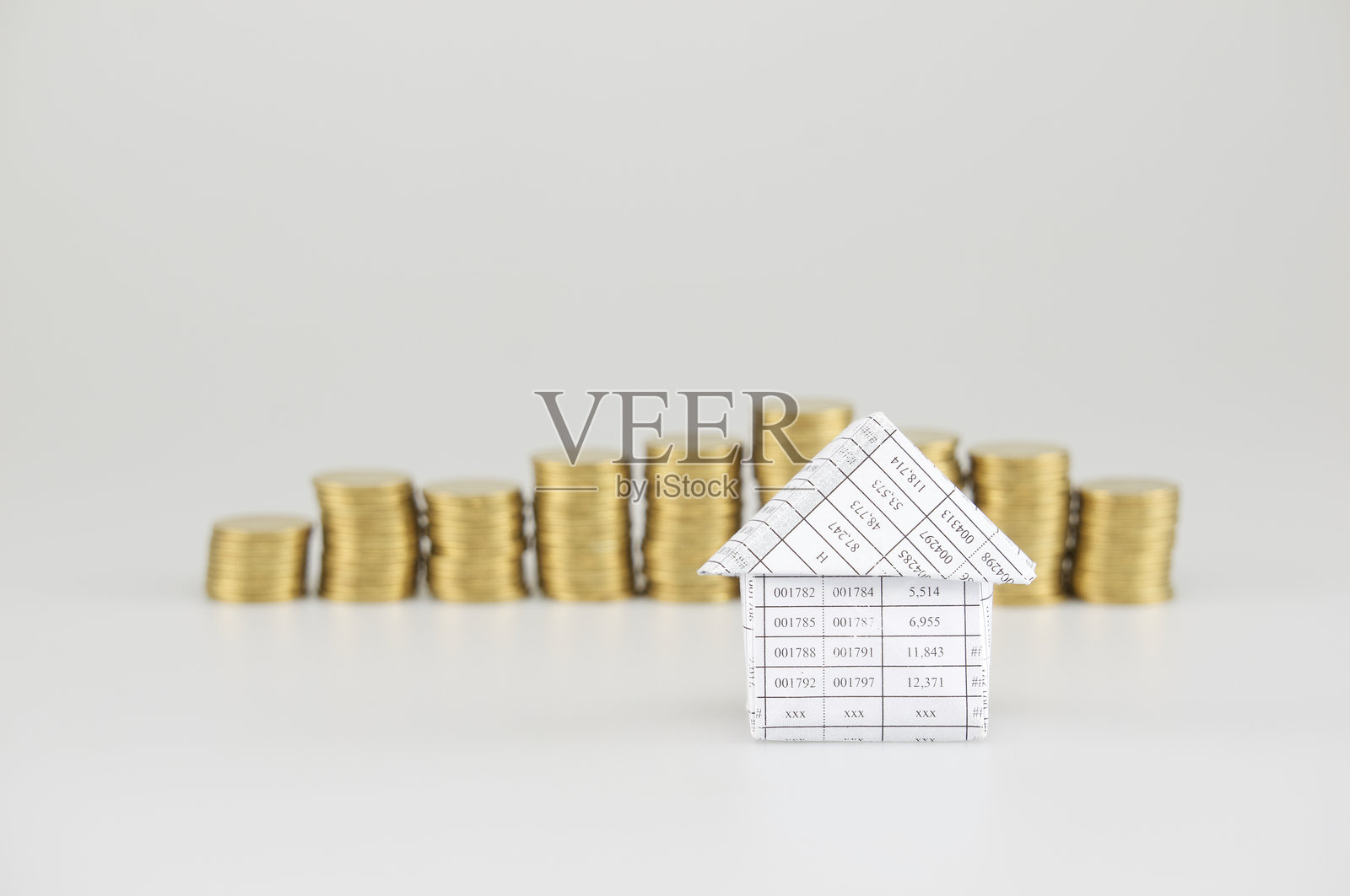 模特房屋特写与堆叠硬币在灰色背景下照片摄影图片