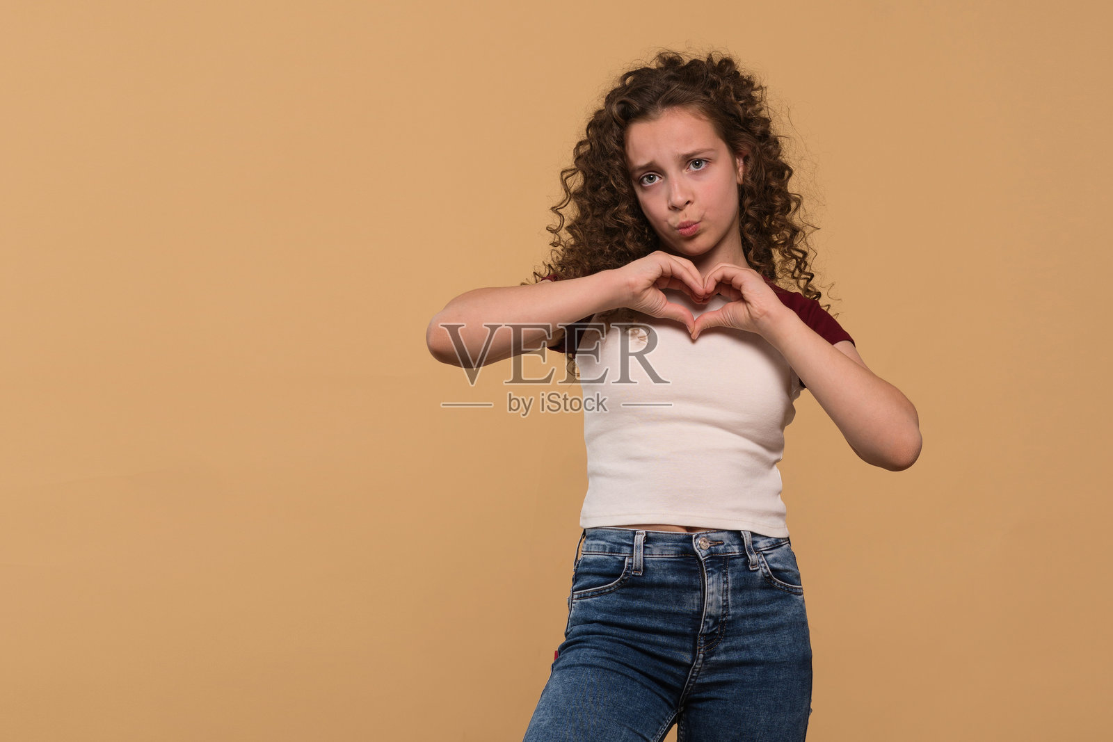 小女孩用手做心形手势，表达爱意照片摄影图片