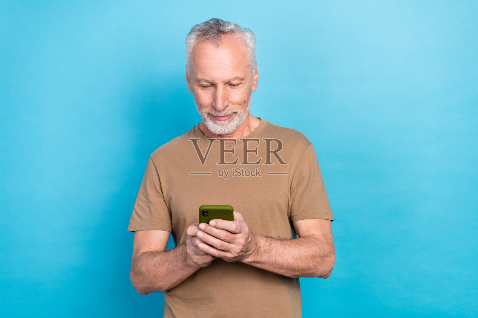 吸引人的成功男士，穿着时尚，沉迷于阅读新闻，滚动查看Facebook、Twitter和Instagram，背景为蓝色。照片摄影图片