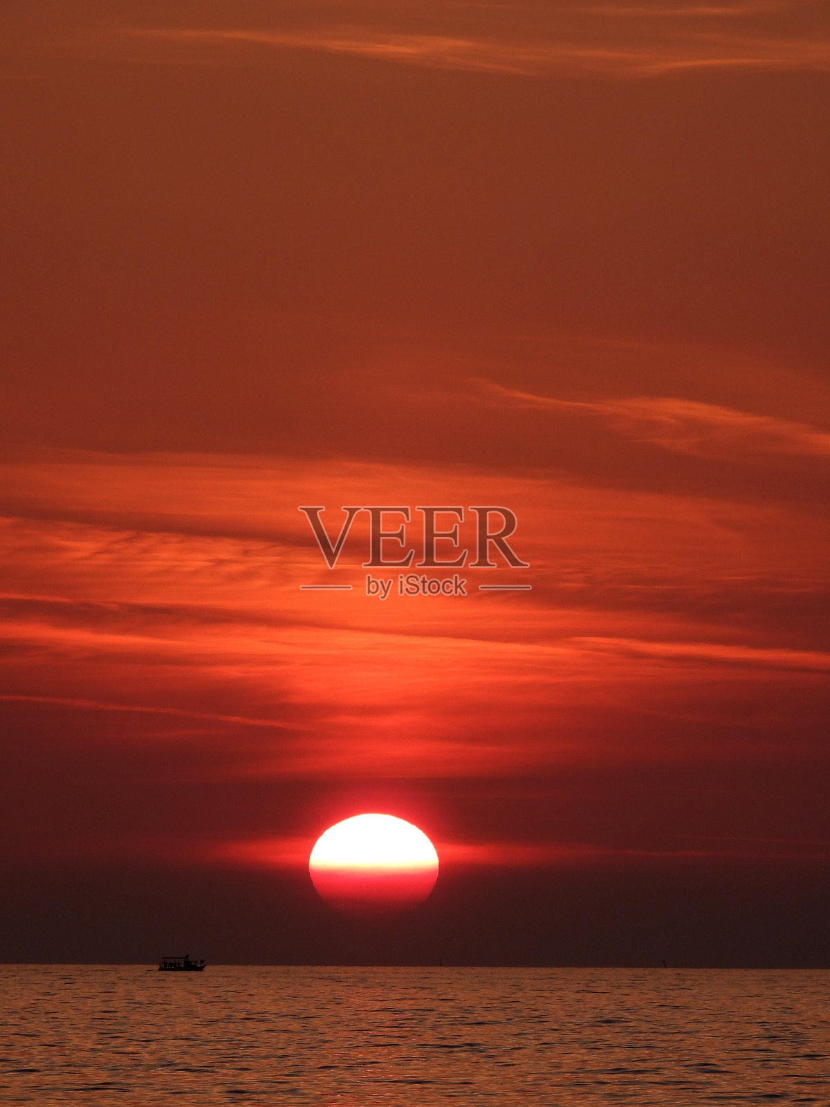 海边日落时极度放大的太阳照片摄影图片