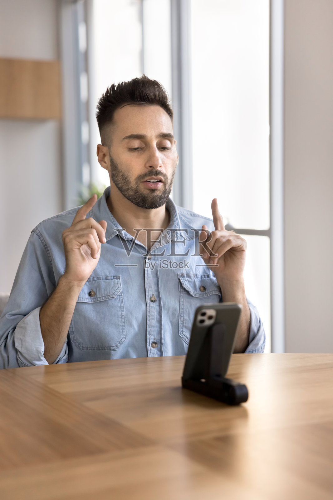 严肃的拉丁裔网红男士在手机上与修理工交谈照片摄影图片