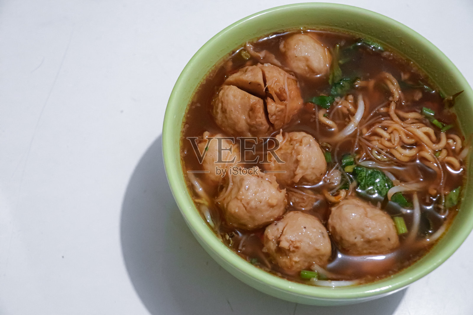 碗中盛着肉丸，配有蔬菜和面条的特写镜头照片摄影图片