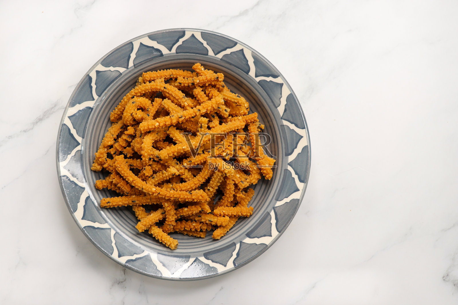 脆炸自制的芝麻查克利棒。查克利是一种来自印度的咸味小吃，由大米、混合的黄绿扁豆和香料制成。通常在排灯节期间食用。照片摄影图片