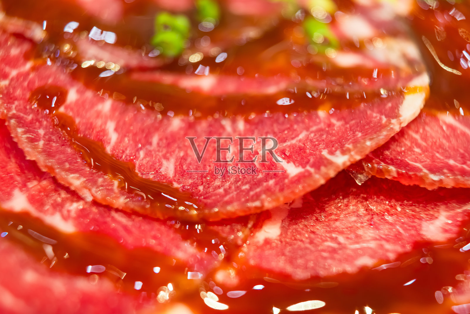 生牛肉的特写，带有酱汁，完美适合烹饪爱好者。照片摄影图片