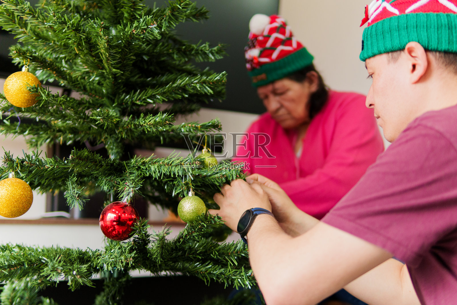 一男一女正在装饰圣诞树照片摄影图片