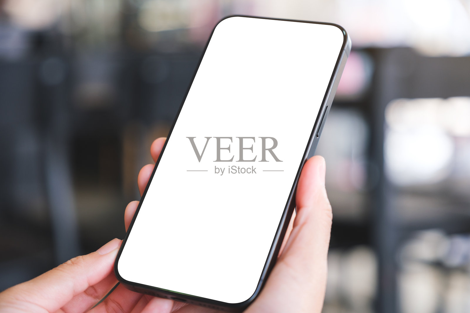 女性在咖啡馆里手持手机并使用，桌面空白的模拟图像照片摄影图片