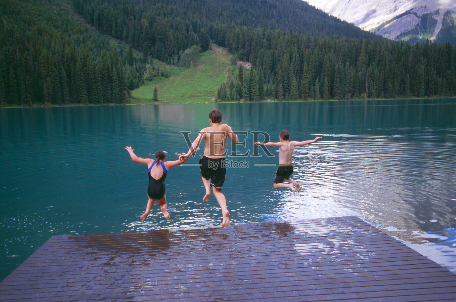 孩子们跳入高山湖泊照片摄影图片