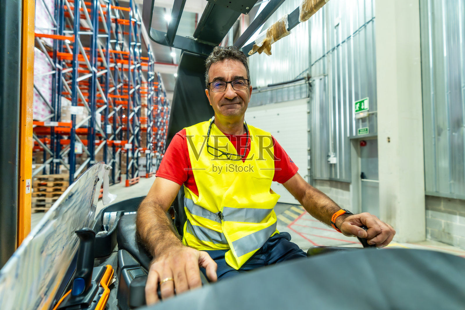 快乐的男性工人在配送仓库驾驶叉车照片摄影图片