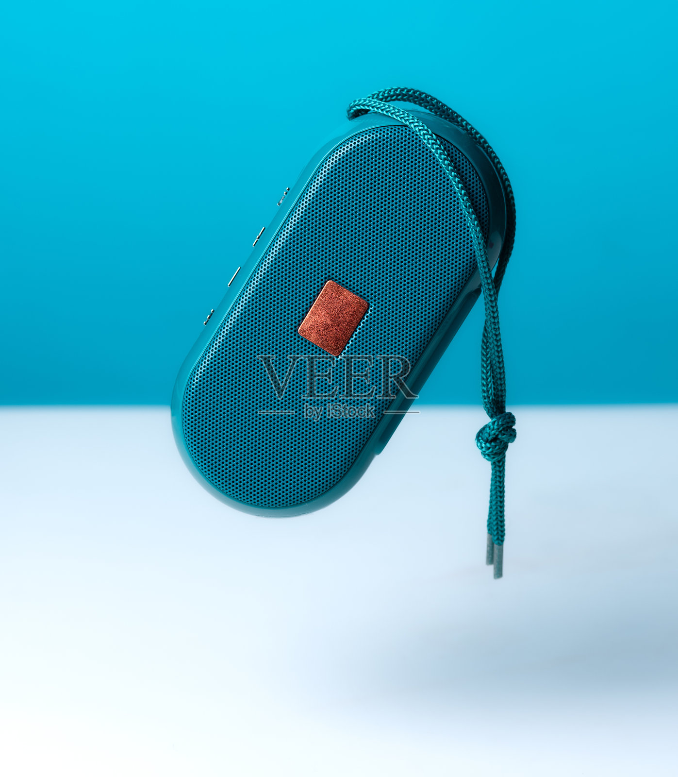 绿色背景上的便携式无线扬声器照片摄影图片