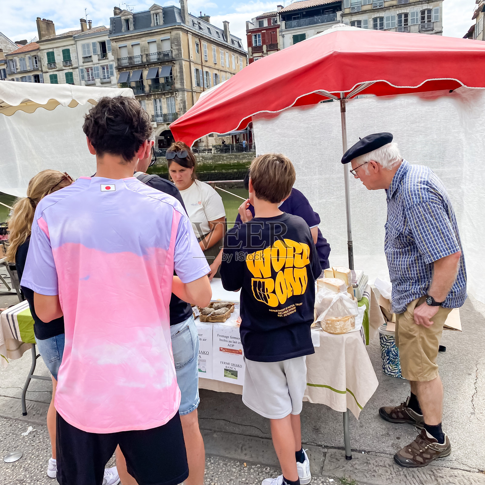 游客在法国巴约讷的食品市场品尝奶酪照片摄影图片