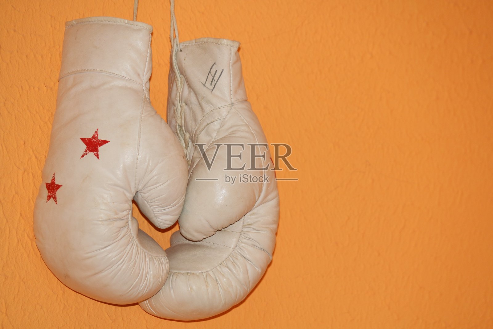拳击手套靠墙悬挂的特写镜头照片摄影图片