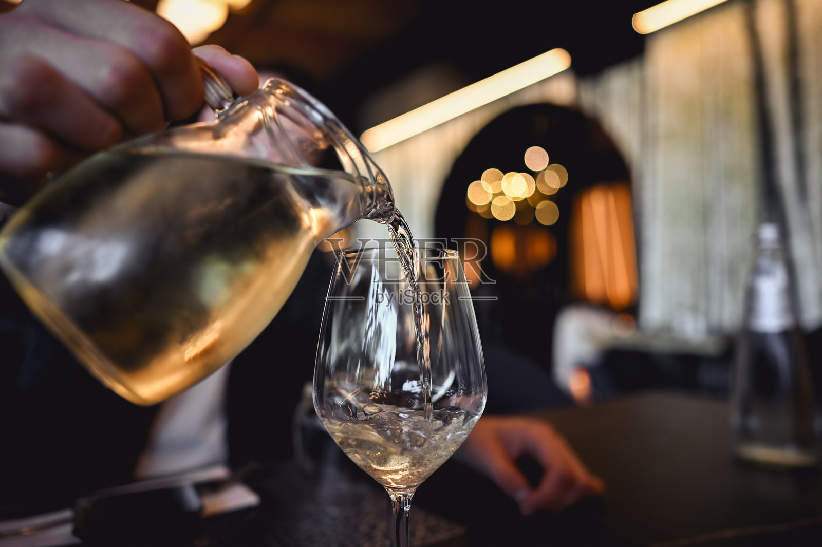 倒白葡萄酒。照片摄影图片