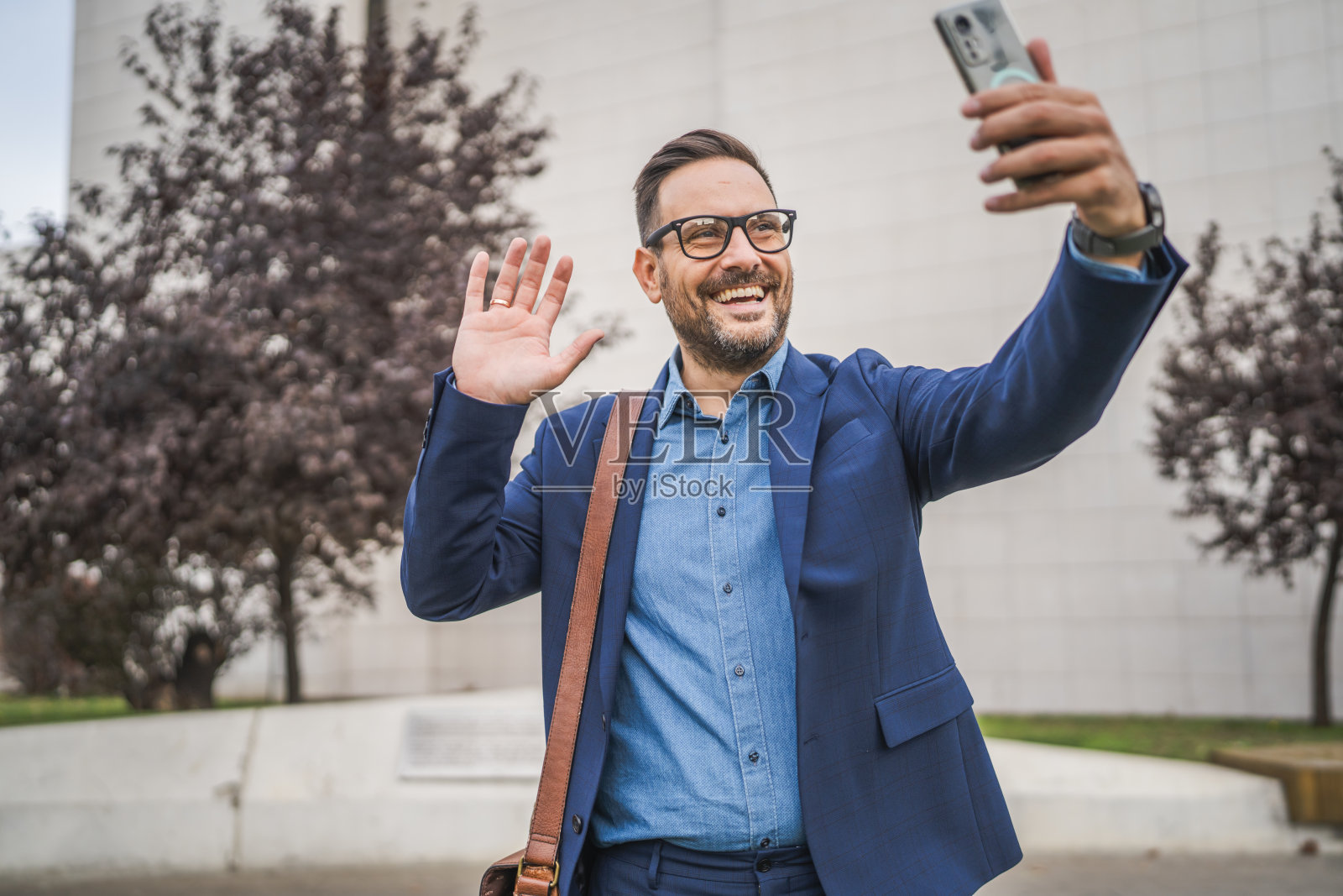 欢迎的商人在户外进行视频通话或自拍照片摄影图片