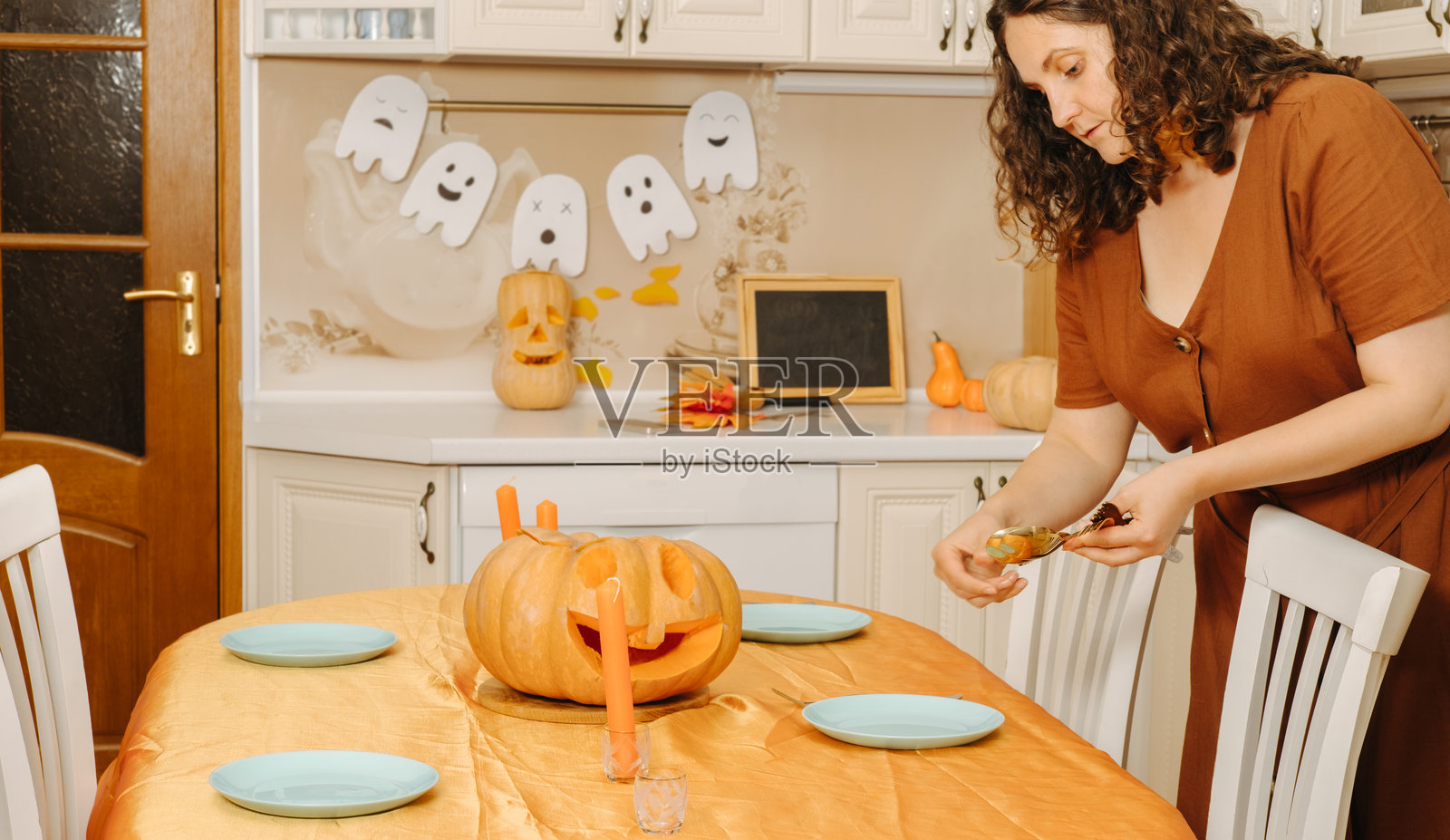 一位中年女性为万圣节派对布置餐桌照片摄影图片