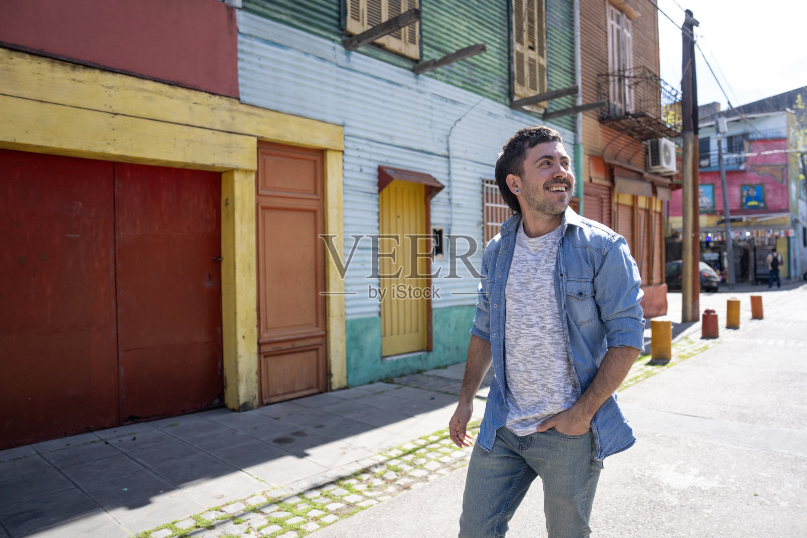 年轻男子在阿根廷布宜诺斯艾利斯的拉博卡街区散步照片摄影图片