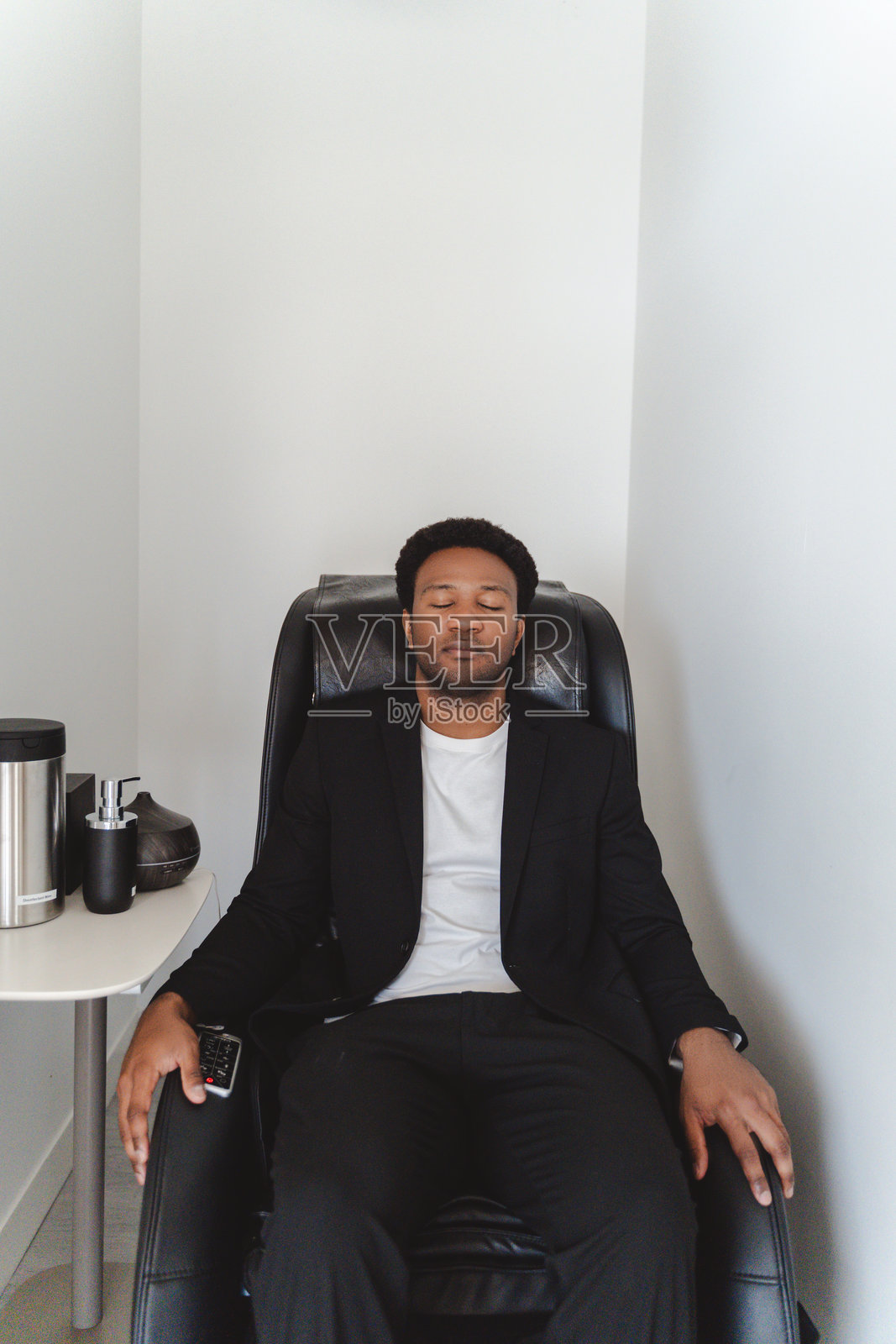 商人在工作后放松地坐在按摩椅上照片摄影图片