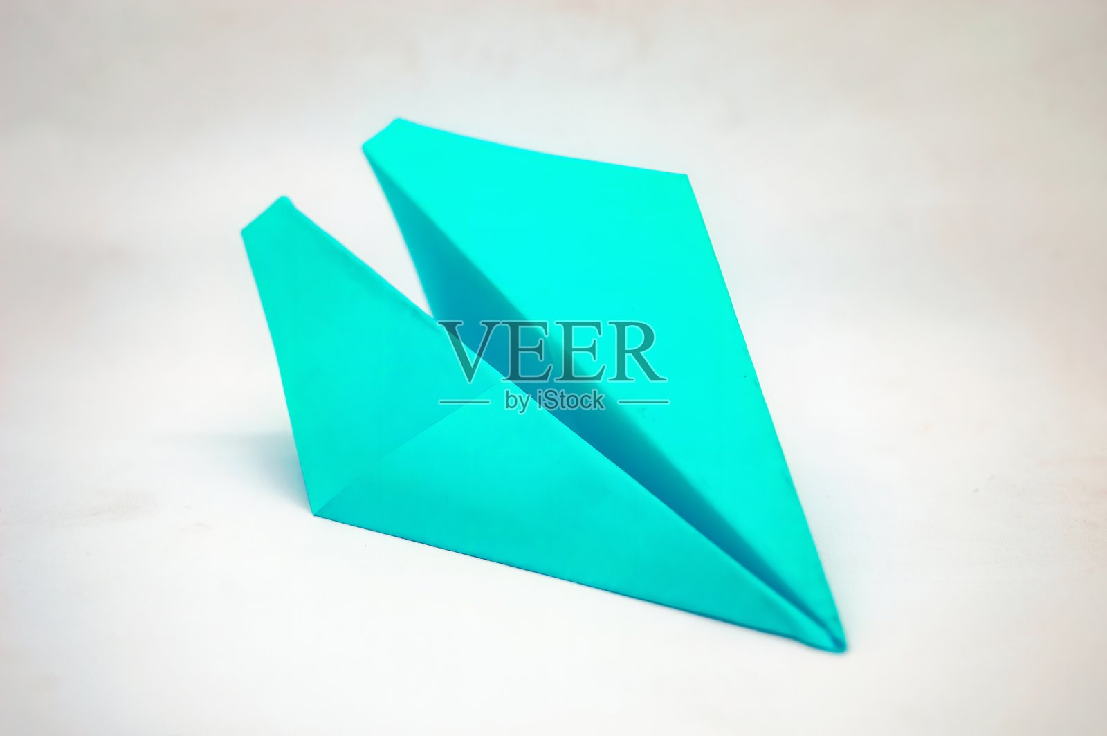 一架简单的青绿色纸飞机，准备起飞。非常适合极简设计、儿童书籍，或作为梦想和抱负的象征。照片摄影图片