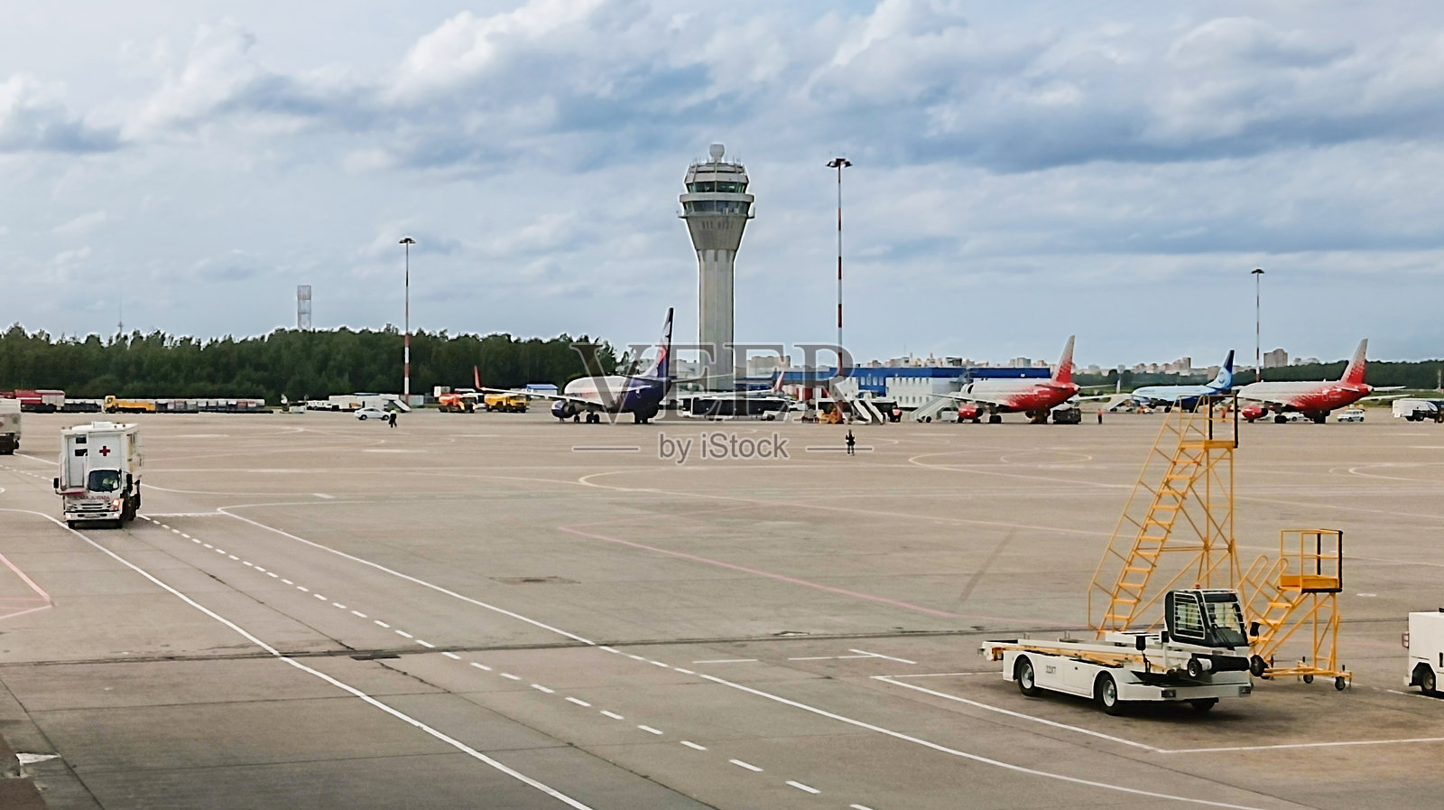 几架飞机停在机场停车区靠近控制塔。照片摄影图片