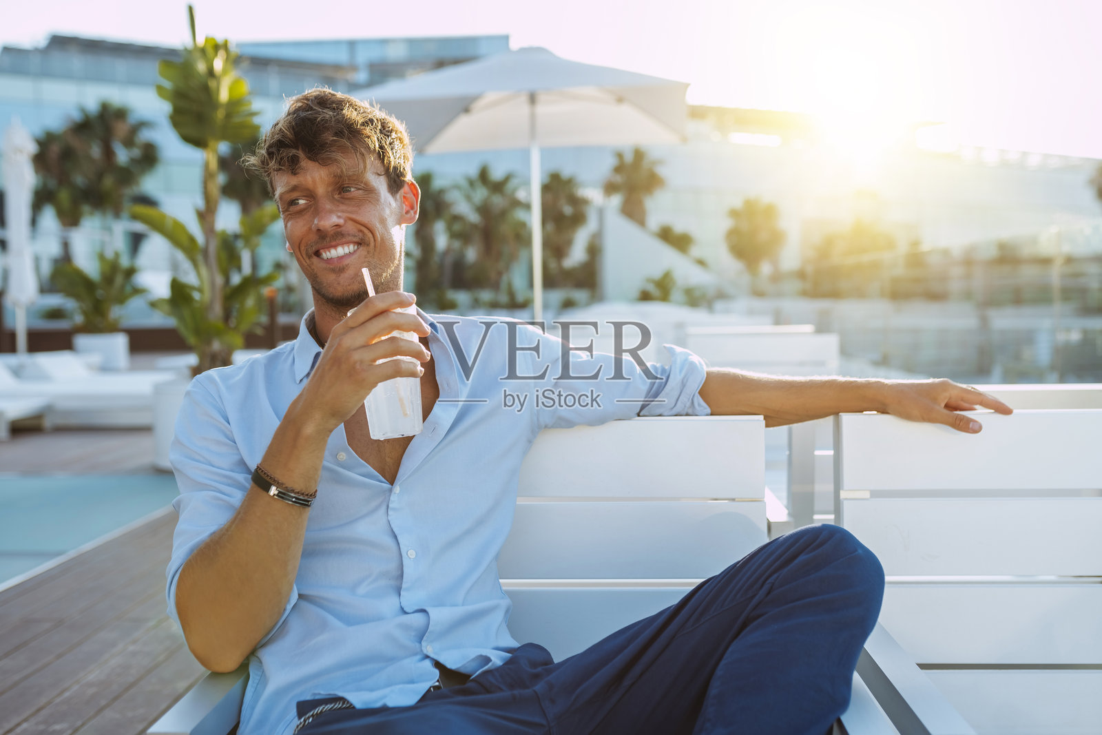 帅气的男人在酒店露台上喝鸡尾酒照片摄影图片