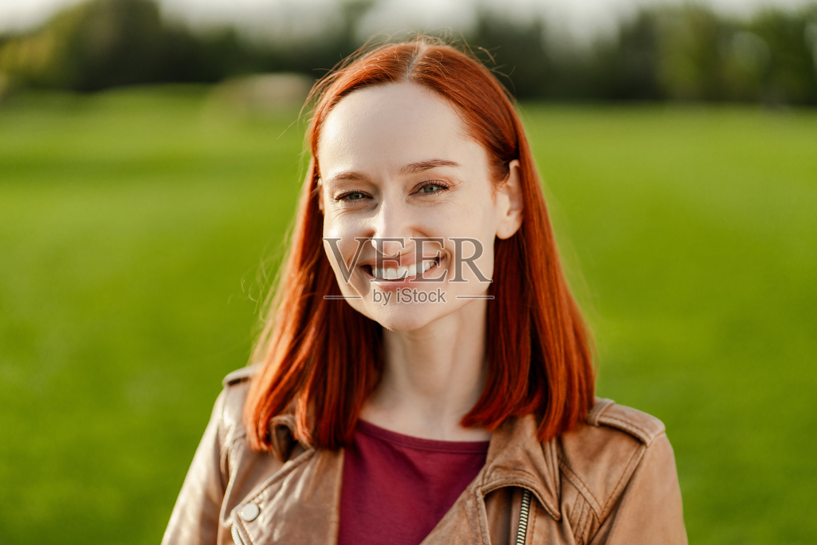 美丽的红发女性在田野中微笑照片摄影图片