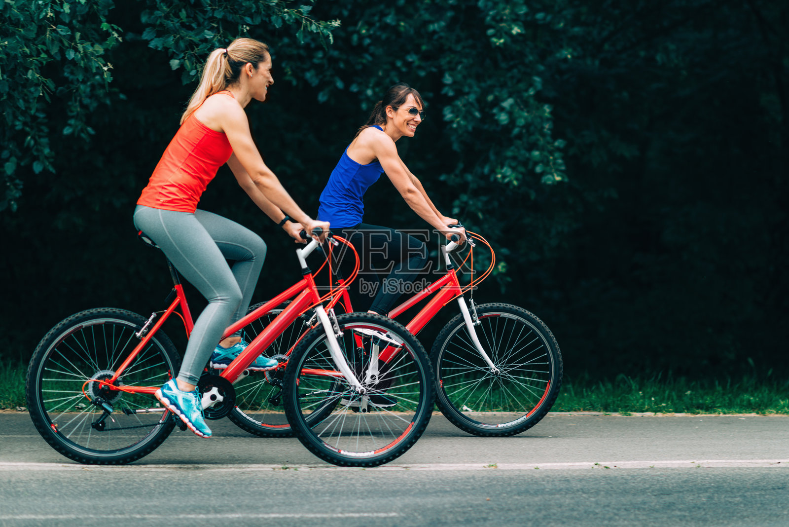 两个女人在路上骑自行车照片摄影图片