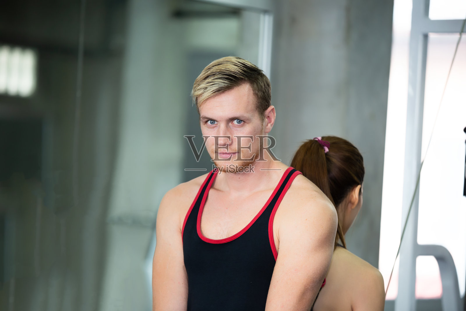 一个年轻人和朋友在健身房锻炼照片摄影图片