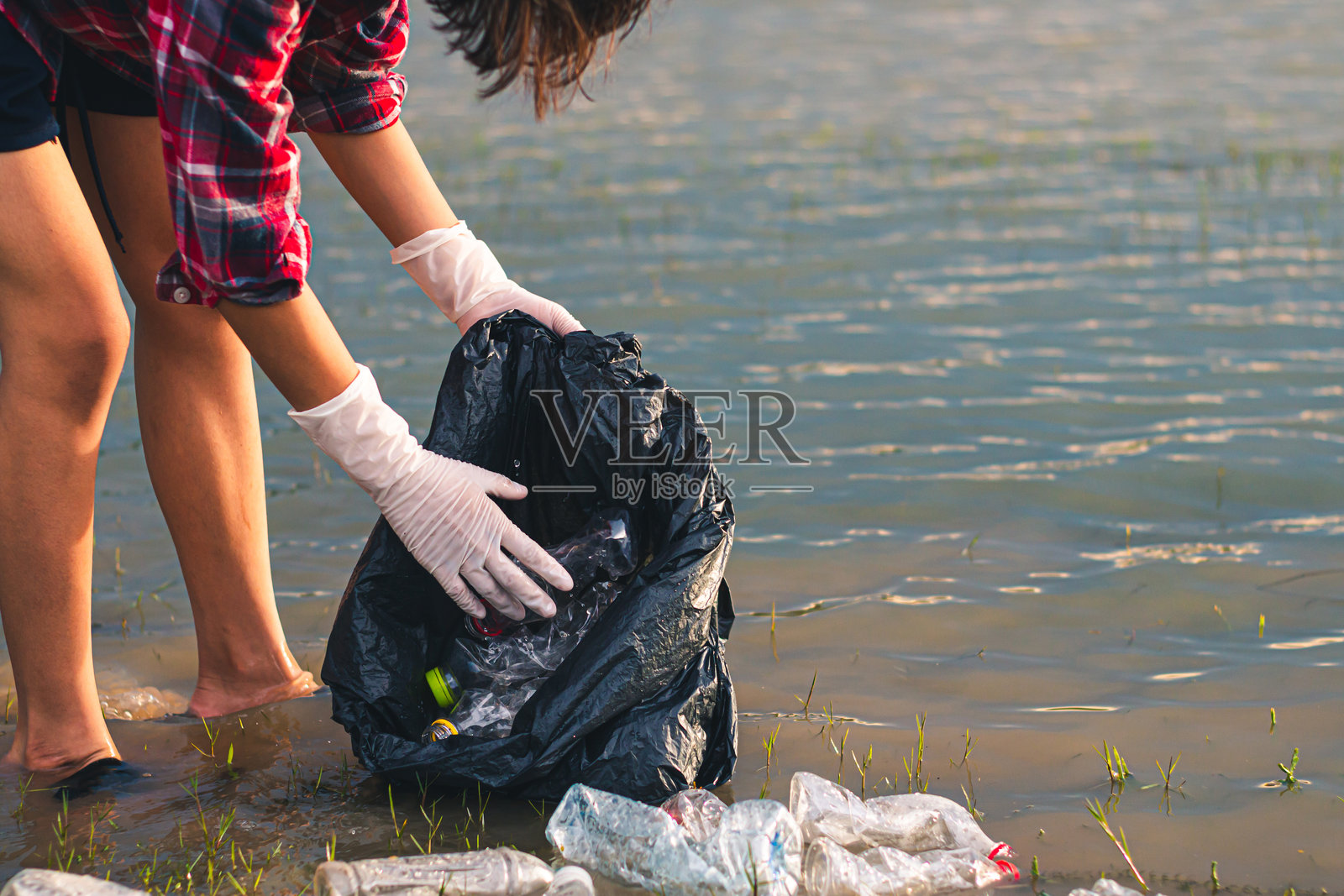 女性志愿者帮助回收垃圾。照片摄影图片