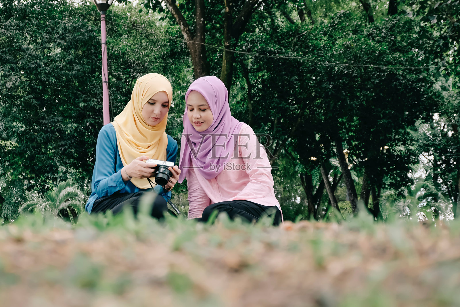 朋友拿着相机在球场上的女人照片摄影图片