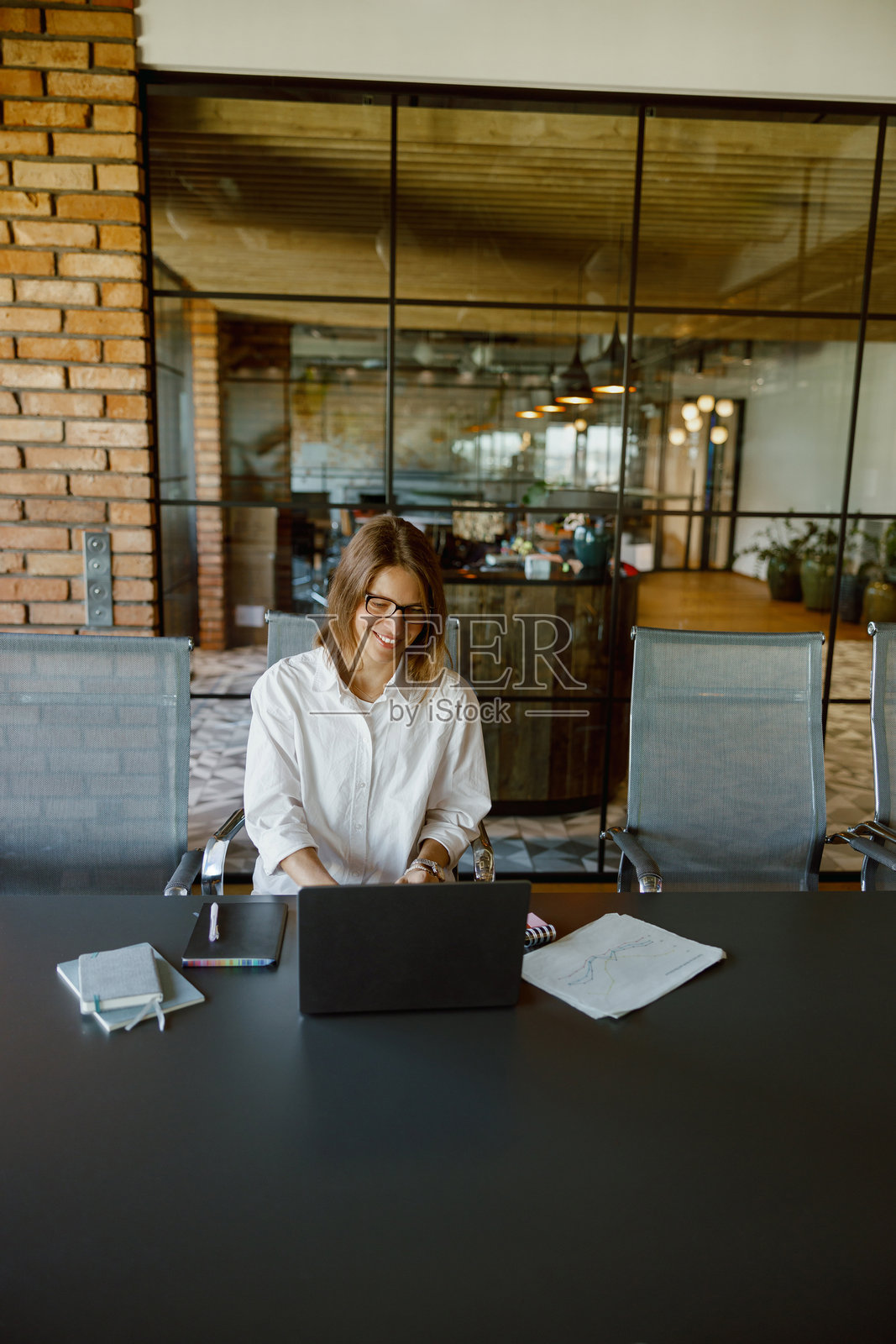 一位专业女性在现代办公室环境中使用笔记本电脑工作照片摄影图片