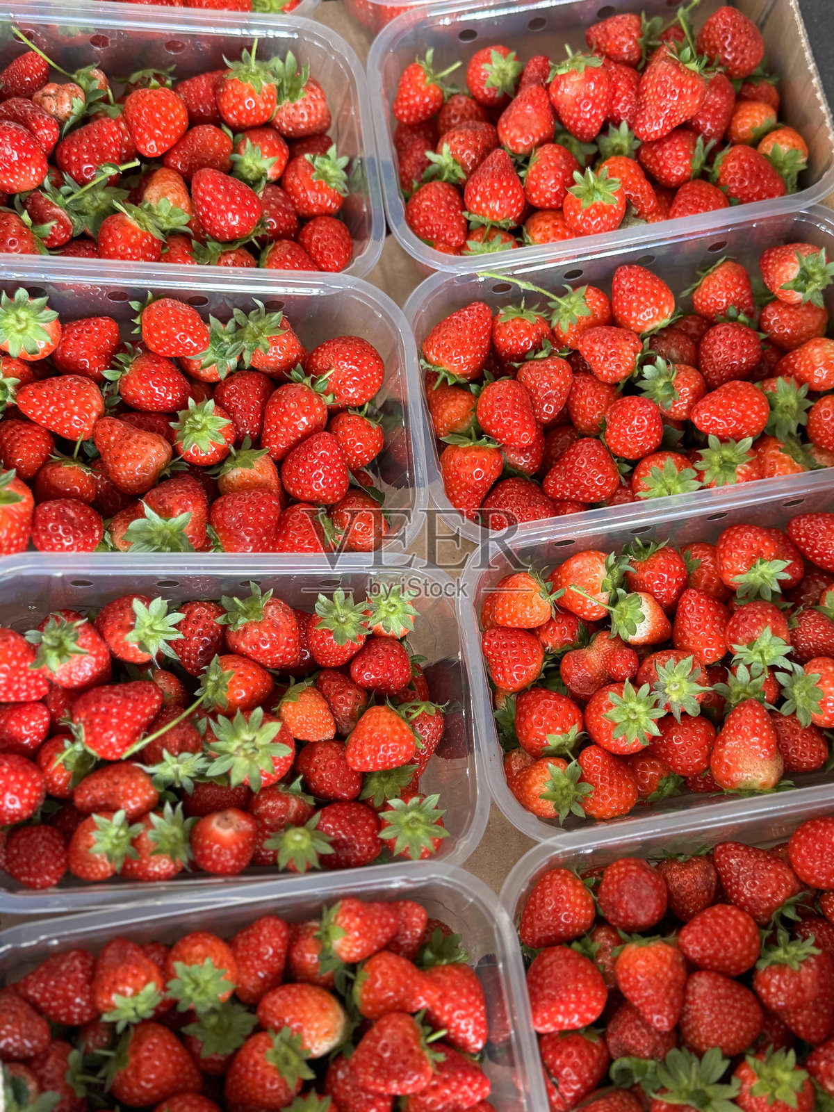 农场商店的农产品展示全景，纸箱托盘上装满了装有草莓（Fragaria × ananassa）的开放塑料小盒，从高处俯视。照片摄影图片