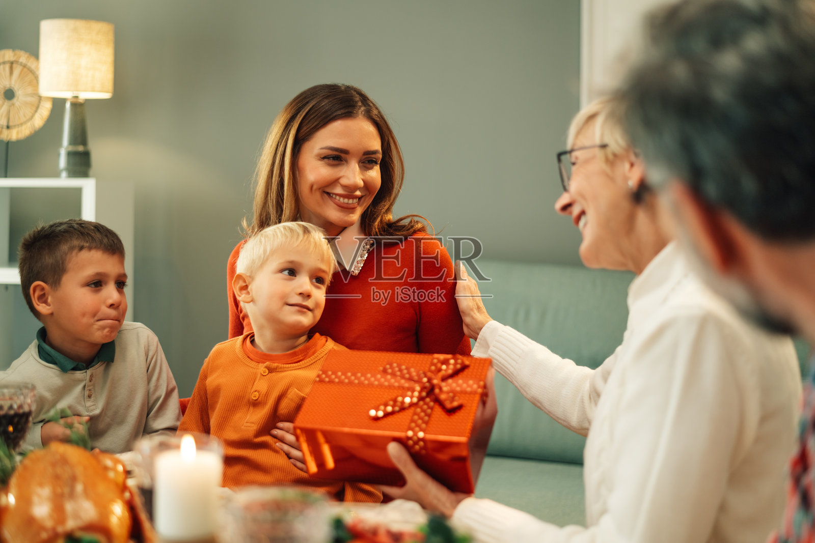 快乐的家庭在圣诞晚餐桌上互赠礼物照片摄影图片