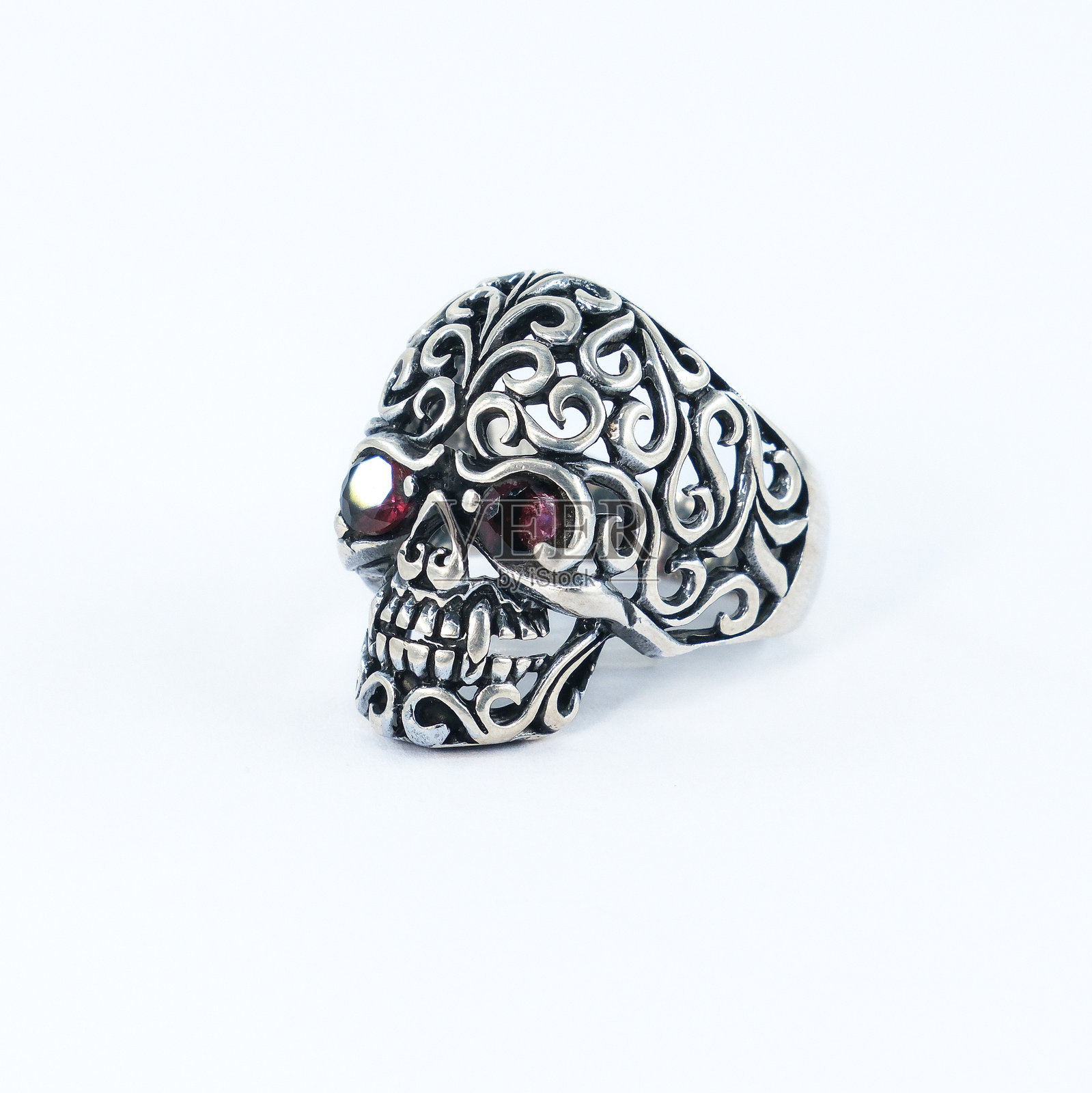 一枚原始戒指，带有红色石头制成的骷髅形状眼睛照片摄影图片