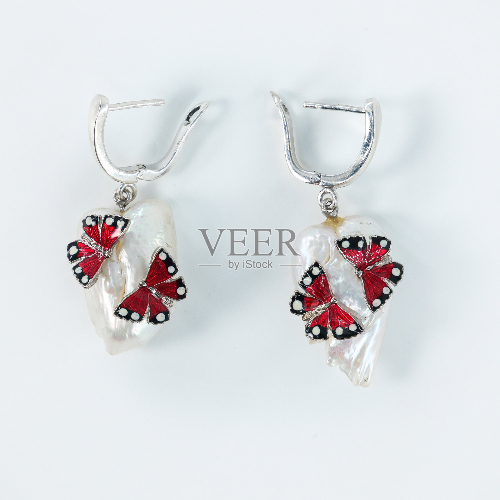 带有红色宝石和蝴蝶图案的银耳环照片摄影图片