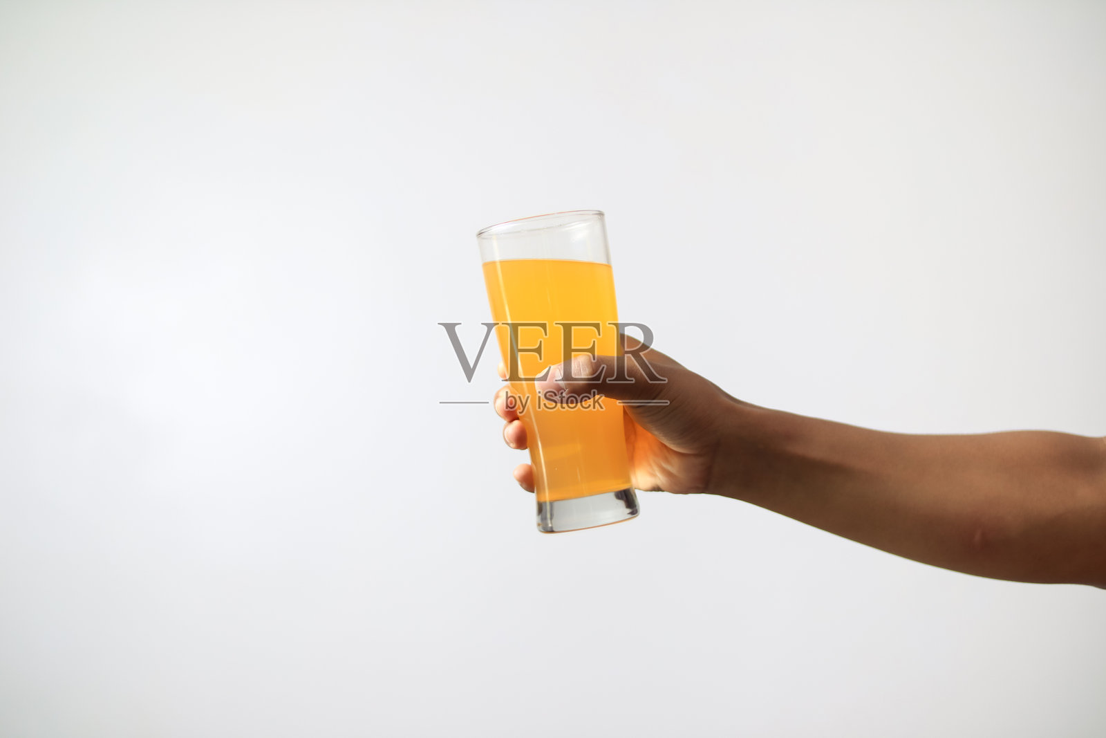 手握橙汁的白色背景照片摄影图片