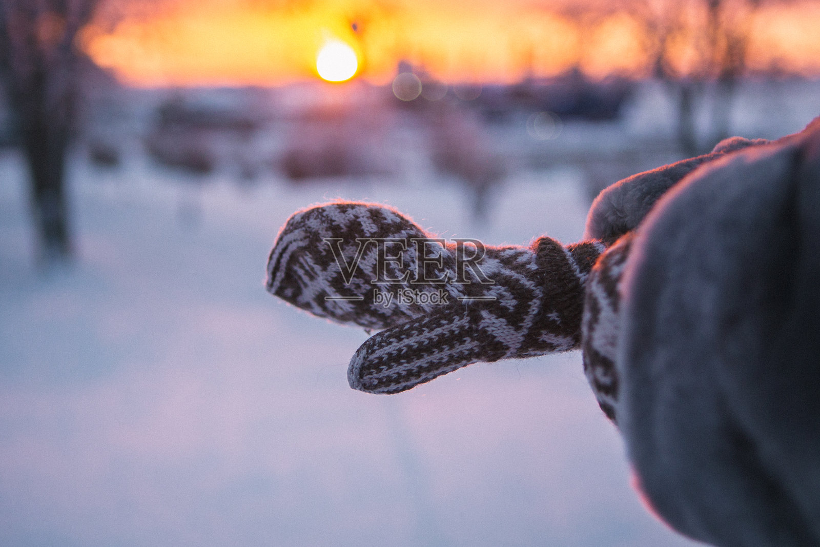 一个人在户外的雪地里穿着一双温暖的手套。照片摄影图片