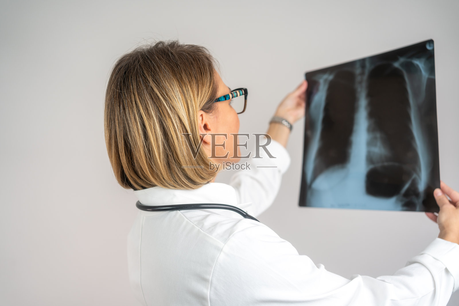 女性西班牙裔医生检查胸部X光片照片摄影图片