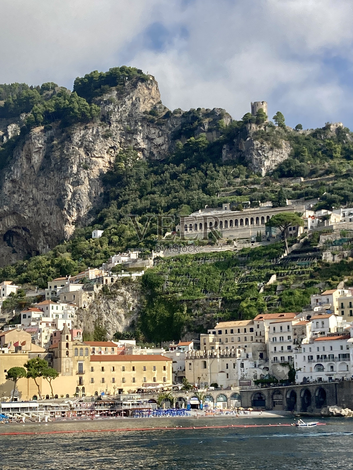 从渡轮上俯瞰意大利阿马尔菲海岸线，展现出壮丽的全景，崎岖的悬崖、迷人的村庄和清澈的地中海水域尽收眼底。照片摄影图片