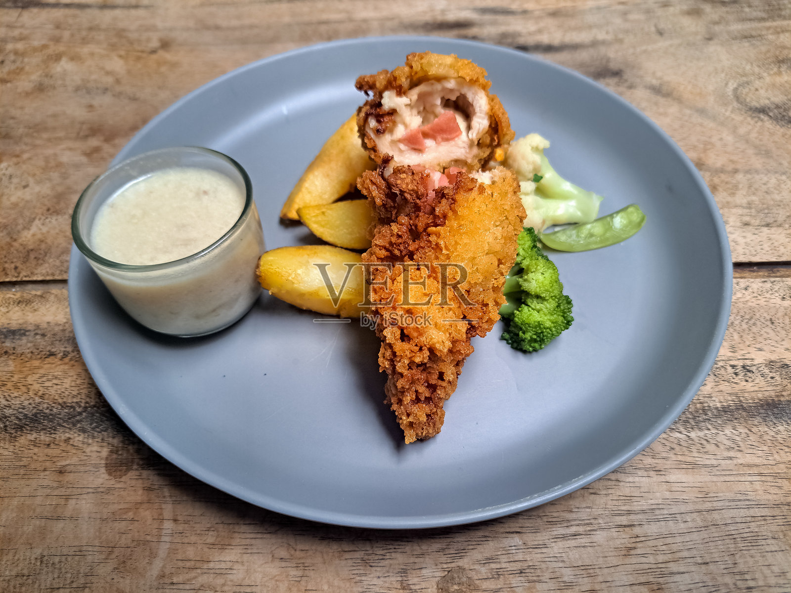 美味的蓝带鸡配土豆角、雪豆、西兰花、胡萝卜和蘑菇酱。菜单。照片摄影图片